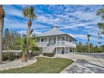 Charming waterfront home with a metal roof and expansive porch at 4027 Siren Rd, Venice, FL 34293