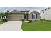 One-story house with green lawn and attached garage at 4608 Halls Mill Xing, Ellenton, FL 34222