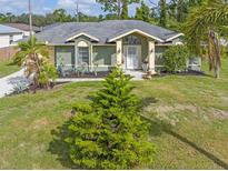 Single-story home with green exterior, landscaping, and driveway at 5375 Joslyn Ter, Port Charlotte, FL 33981