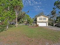 Charming two-story home with a well-manicured lawn, white picket fence and attached two-car garage at 5411 9Th E St, Bradenton, FL 34203