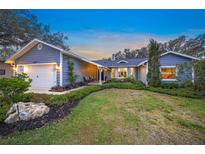 Gray house with landscaped yard, two-car garage, and inviting front porch at 6207 93Rd Street E Cir, Bradenton, FL 34202