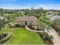 Luxury home with pool and lush landscaping on a golf course at 654 Trenton Way, Osprey, FL 34229