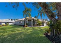 Single-story house with green walls, tile roof, and palm trees at 7203 41St E Ct, Sarasota, FL 34243