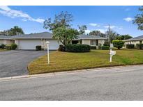Front yard view of the house with a well-maintained lawn at 7460 W Country Club N Dr, Sarasota, FL 34243