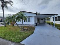 White single-wide manufactured home with carport and palm tree at 808 53Rd E Ave # 76, Bradenton, FL 34203