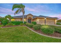 Tan house with lush landscaping, double garage, and palm tree at 9100 Yarberry St, Sarasota, FL 34240