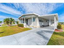 Single-wide manufactured home with carport and landscaped yard at 1108 43Rd Avenue E Dr, Ellenton, FL 34222