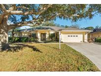 Single-story house with two-car garage and mature oak tree providing shade at 3298 Branch Creek Dr, Sarasota, FL 34235