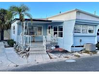 Light blue mobile home with covered porch, steps, and palm tree at 3710 Gulf Of Mexico Dr # G-6, Longboat Key, FL 34228