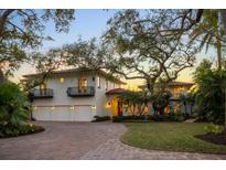 Luxury waterfront home with three-car garage, mature landscaping, and brick driveway at 3930 Red Rock Way, Sarasota, FL 34231