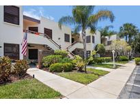 Exterior view of condo building with lush landscaping and walkway at 401 Spring Lakes Blvd # 401, Bradenton, FL 34210