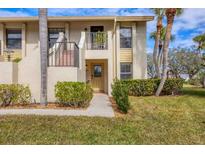 Two-story condo building with lush landscaping and palm trees at 4402 Weybridge St # 95, Sarasota, FL 34235