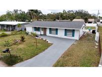 Updated home with gray driveway and teal accents, a pool, and fenced backyard at 4609 19Th W St, Bradenton, FL 34207