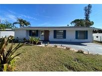 Charming ranch home with teal accents and landscaped lawn at 4609 19Th W St, Bradenton, FL 34207