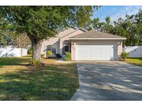 House exterior featuring a two-car garage and well-maintained lawn at 4927 69Th E Ct, Palmetto, FL 34221