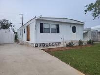 White single-wide mobile home with a shed and small yard at 4969 Pebble Beach Ave, Sarasota, FL 34234