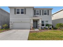 Two-story house with gray siding, stone accents, and a two-car garage at 5216 Adega Way, Bradenton, FL 34211