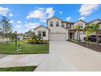 Two-story house with light-colored exterior, two-car garage, and landscaped lawn at 5564 Coachwood Cv, Bradenton, FL 34211