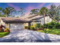 Inviting home exterior featuring a paved driveway and lush landscaping at 5625 Pipers Waite # 9, Sarasota, FL 34235