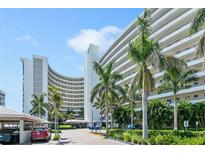 Front view of a modern condo building with palm trees and ample parking at 6300 Midnight Pass Rd # 810, Sarasota, FL 34242