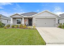 One-story home with gray siding, two-car garage, and landscaped lawn at 6708 162Nd E Pl, Parrish, FL 34219