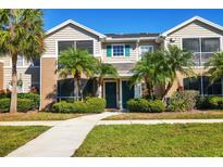 Tan two-story townhome with palm trees and a walkway at 8932 Manor Loop # 207, Lakewood Ranch, FL 34202