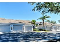 Exterior view of condo building with attached garages and landscaping at 9499 Millbank Dr # 2721, Sarasota, FL 34238