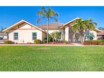 Single-story home with landscaped lawn and palm trees at 1144 Hoover St, Nokomis, FL 34275