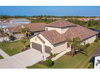 Aerial view of a single-Gathering home with a two-car garage and tile roof at 1748 Still River Dr, Venice, FL 34293