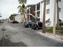 Exterior of condo building with parking lot and landscaping at 2075 Canal Dr # L36, Bradenton, FL 34207