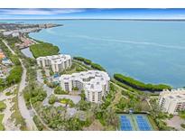 Aerial view of waterfront condo building with tennis courts at 2110 Harbourside Dr # 526, Longboat Key, FL 34228
