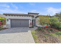 Charming single-story home featuring a paved driveway, gray garage door, and well-manicured landscaping at 328 Aria Dr, Nokomis, FL 34275