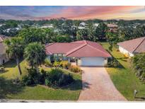 Charming single-story home with red tile roof, mature landscaping, and paved driveway at 395 W Rossetti Dr, Nokomis, FL 34275