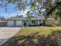 Charming light green house with a two-car garage and landscaped yard at 4819 Greenleaf Rd, Sarasota, FL 34233