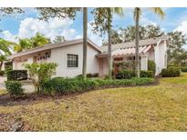 Light pink house with a two-car garage and a landscaped yard at 5432 Hampstead Heath # 26, Sarasota, FL 34235