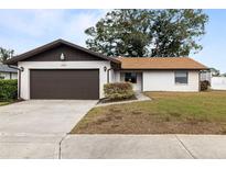 Single-story home with brown garage door and landscaped lawn at 5506 3Rd Avenue W Plz, Bradenton, FL 34209