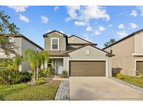 Two-story house with a two-car garage and landscaped front yard at 5546 Appleton Shore Dr, Apollo Beach, FL 33572