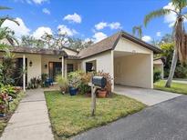 Inviting exterior with carport and landscaped walkway at 6946 Woodwind Dr # 2, Sarasota, FL 34231