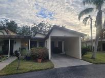 Exterior view of a condo with carport, landscaping, and a mailbox at 6946 Woodwind Dr # 2, Sarasota, FL 34231