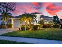 Attractive single-story home with landscaped yard, a paved driveway, and a two-car garage at 6947 Lennox Pl, University Park, FL 34201