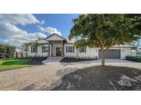 Beautiful waterfront home with a metal roof, landscaping, and a 2-car garage at 7820 Holiday Dr, Sarasota, FL 34231