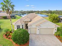 Single-story home with tile roof, two-car garage, and landscaped lawn at 9109 Winter Harbour Way, Bradenton, FL 34212