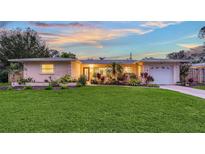 Updated Florida Ranch home with a well manicured lawn and a newly paved driveway at 2651 Leafy Ln, Sarasota, FL 34239