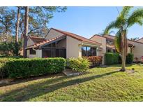 Condo exterior showcasing a tiled roof and lush landscaping at 5343 Huntingwood Ct # 33, Sarasota, FL 34235