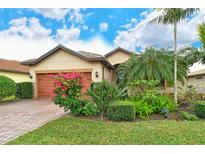 Single-story home with landscaped yard and two-car garage at 5931 Caspian Tern Dr, Sarasota, FL 34238