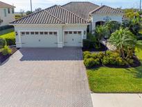 Exterior of a single-Gathering home with a three-car garage and landscaped yard at 7817 Passionflower Dr, Sarasota, FL 34241
