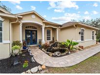 Front entry with blue door and brick walkway at 8107 High Oaks Trl, Myakka City, FL 34251