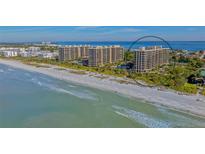 Aerial view of beachfront condo building with tennis courts and pool at 1211 Gulf Of Mexico Dr # 603, Longboat Key, FL 34228