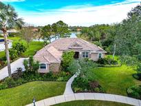 Single-Gathering home with tile roof, lush landscaping, and walkway, near a lake at 16806 5Th Ne Ter, Bradenton, FL 34212