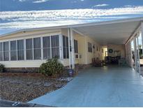 Yellow mobile home with carport and covered patio at 2107 Palma Sola Blvd # 27, Bradenton, FL 34209